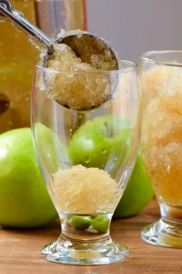 An ice cream scoopers scoops in some of the Apple Brandy Slush into glasses. 