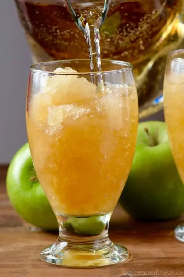 Some of the Apple Brandy Slush in the glass, and some of the ginger ale being poured into it. 