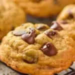 close up of a pumpkin chocolate chip cookie on a wire cooling rack