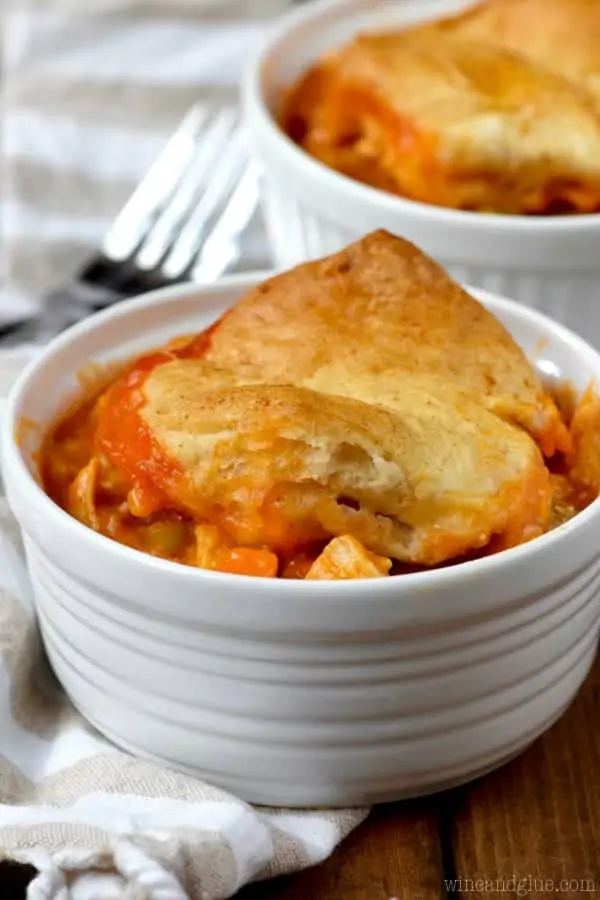 In a white bowl, a scoopful of the Buffalo Chicken Pot Pie fills it up and covered with a golden brown biscuit. 
