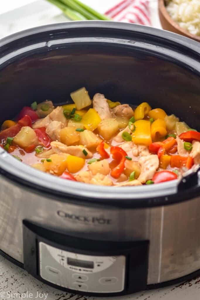 side view of crockpot sweet and sour chicken in a slow cooker