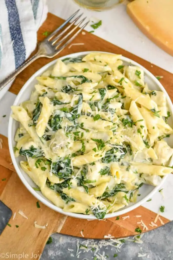 overhead view of a plate of spinach artichoke chicken pasta recipe