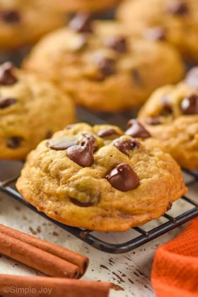 close up of a pumpkin chocolate chip cookie on a wire cooling rack