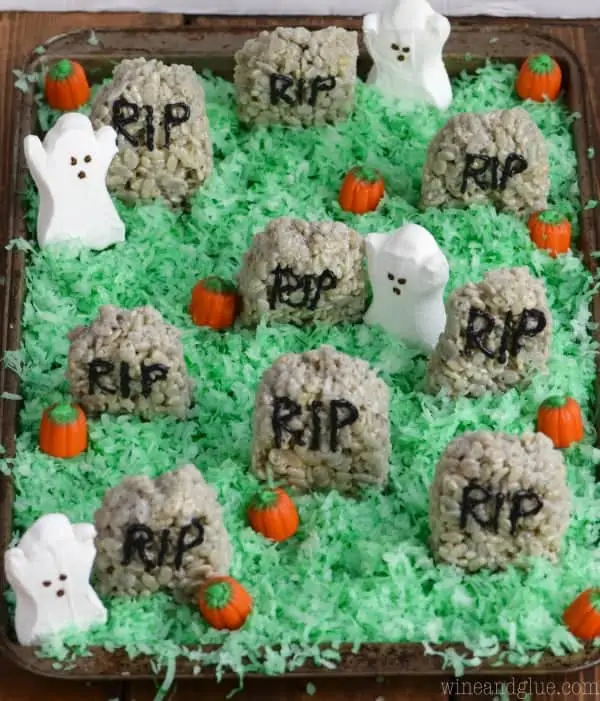Green coconut flakes are sprinkled everywhere like grass, and on top of the "grass" there are pumpkin candy corn, Rice Krispies Treat Hedge Stones, and ghost marshmallows.