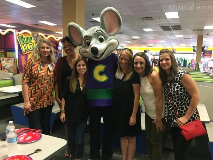A group of women standing next to Chuck E. Cheese. 