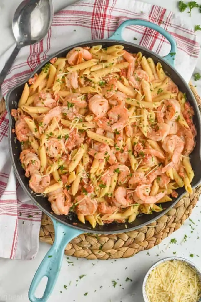 overhead view of creamy shrimp pasta recipe garnished with parsley and parmesan. 