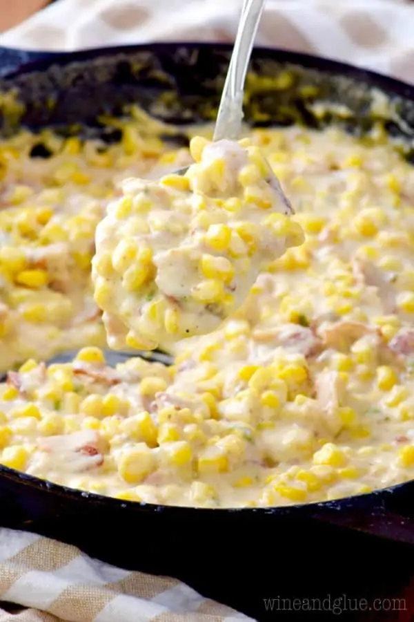 In a cast iron skillet, the Bacon Jalapeno Cream Corn is very creamy and colorful from the corn, bacon, and jalapenos. 