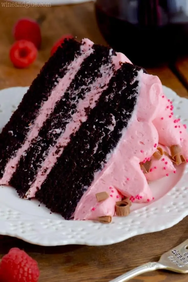 The Red Wine Chocolate cake has three layers with pink frosting in between and topped with pink frosting, pink sprinkles, and shaved chocolate. 