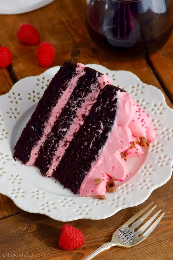 The Red Wine Chocolate cake has three layers with pink frosting in between and topped with pink frosting, pink sprinkles, and shaved chocolate. 