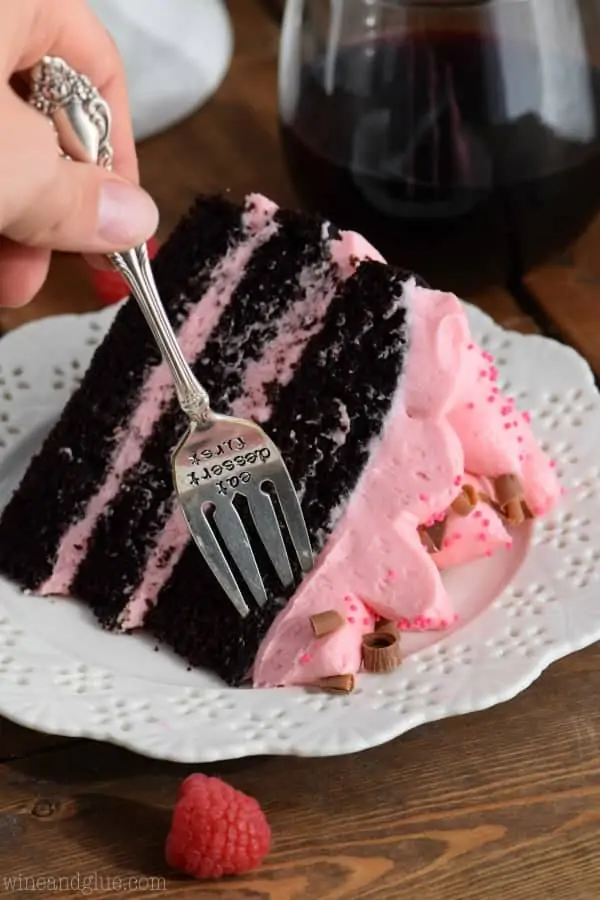 A woman digging her fork into the fluffy Red Wine Chocolate Cake