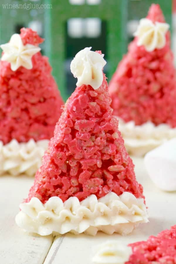 In a triangle shape, the Rice Krispies are dyed a bright red color with frosting on the tip and at the bottom making it look like a Santa's Hat