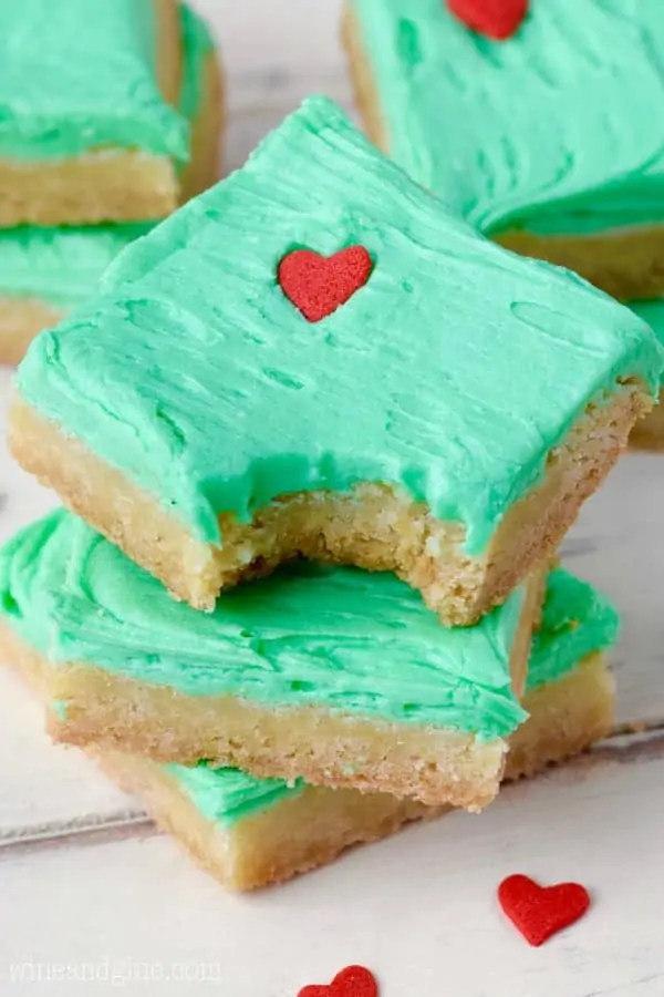 In the shape of little squares, the Grinch Sugar Cookie Bars have the same color green as the Grinch frosting and a heart sprinkle that is 3 sizes too small. 