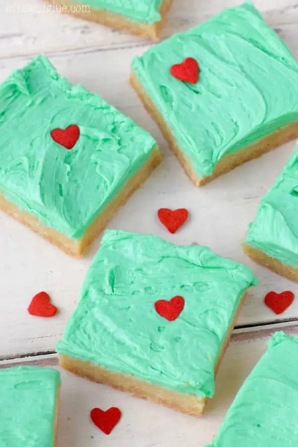 In the shape of little squares, the Grinch Sugar Cookie Bars have the same color green as the Grinch frosting and a heart sprinkle that is 3 sizes too small. 