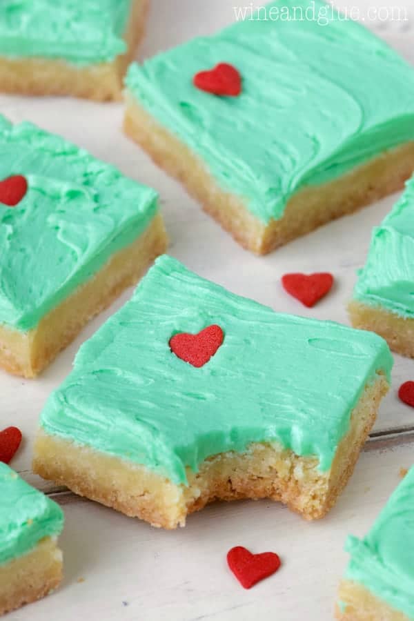 In the shape of little squares, the Grinch Sugar Cookie Bars have the same color green as the Grinch frosting and a heart sprinkle that is 3 sizes too small. 