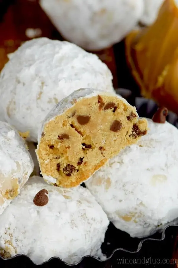 The Peanut Butter Chocolate Chip Snowball Cookies is cut in half showing the mini chocolate chips tossed in powdered sugar. 