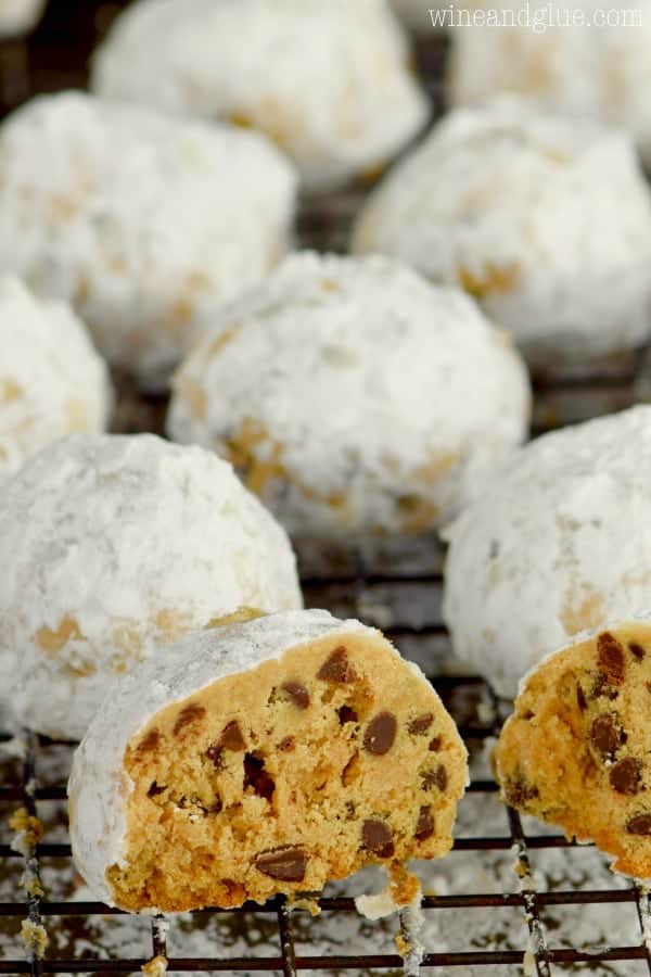 The Peanut Butter Chocolate Chip Snowball Cookies is cut in half showing the mini chocolate chips tossed in powdered sugar. 