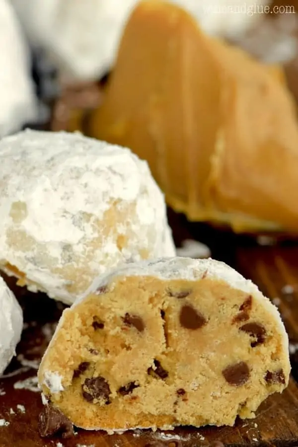 The Peanut Butter Chocolate Chip Snowball Cookies is cut in half showing the mini chocolate chips tossed in powdered sugar. 