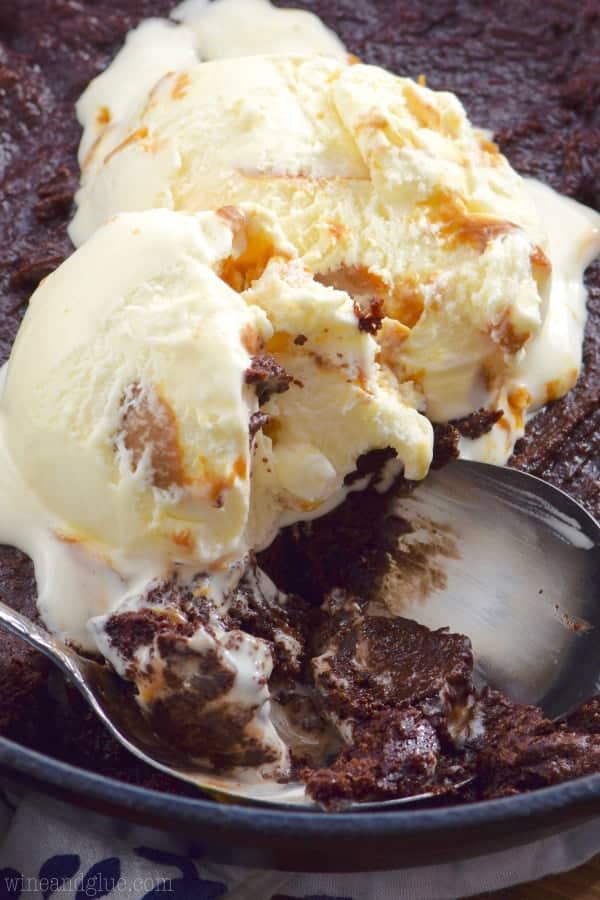 In a cast iron skillet, the Skillet Brownie is topped with caramel gelato. 