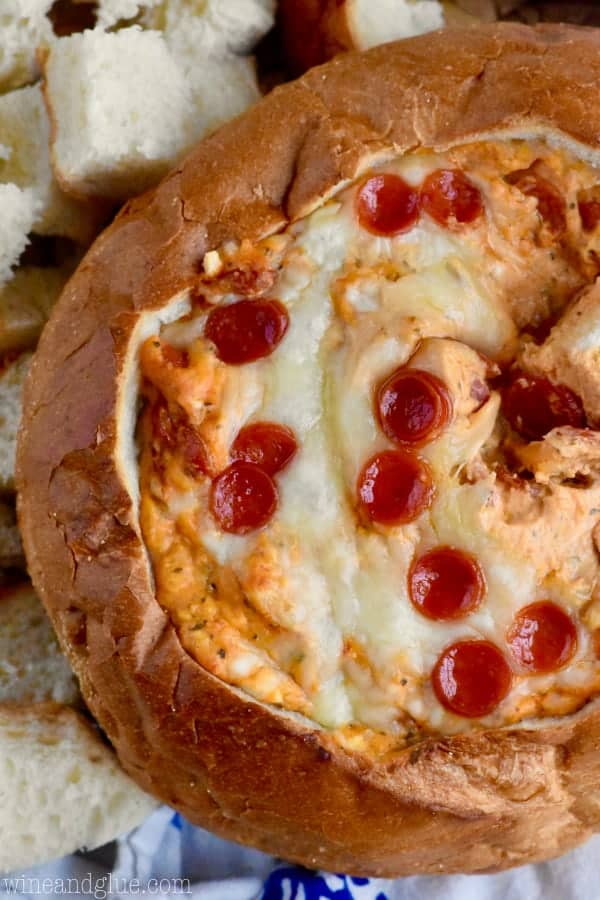 An overhead photo of the Bread Bowl Pizza Dip showing the melted cheese topped with mini pepperoni. 