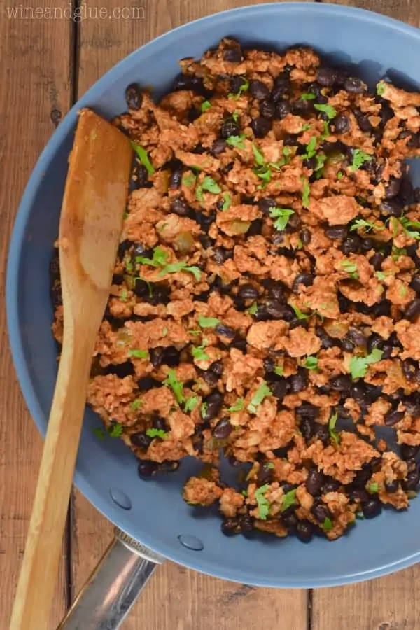 In a sauce pan, the filling for the Southwestern Lettuce Wraps is mixed together-- Turkey meat and beans.