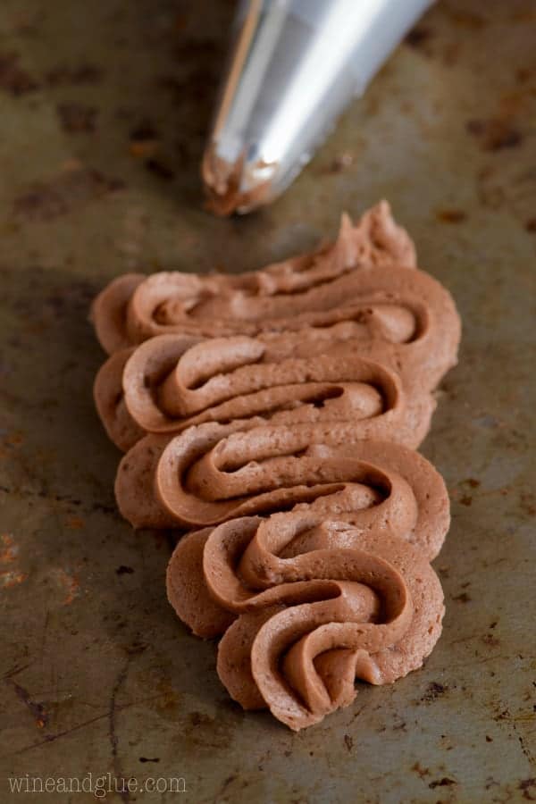 Using a star tip, the Chocolate Buttercream Frosting is piped in a zig-zag shape.