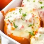 close up of a orange Italian stuffed pepper in a casserole dish