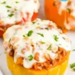 stuffed peppers that are topped with melted mozzarella cheese and garnished with parsley on a platter