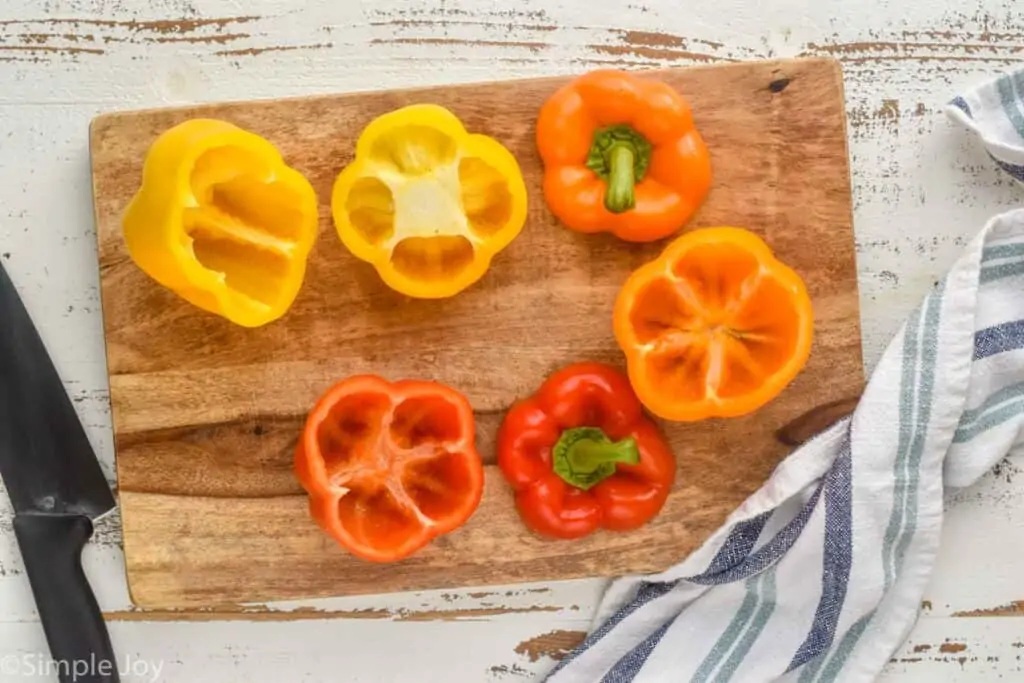 overhead of bell peppers with their tops cut off and hallowed out on a cutting board