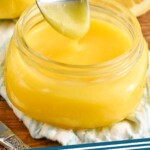Pinterest graphic for Lemon Curd Recipe. Image is overhead photo of a spoon dipping into a jar of Lemon Curd Recipe. Text says, "Lemon curd simplejoy."