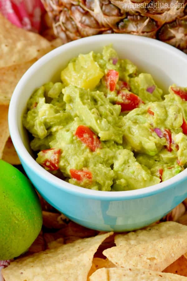 In a bowl blue, the Avocado Salsa shows the array of colors from the tomatoes, avocado, and onion. 