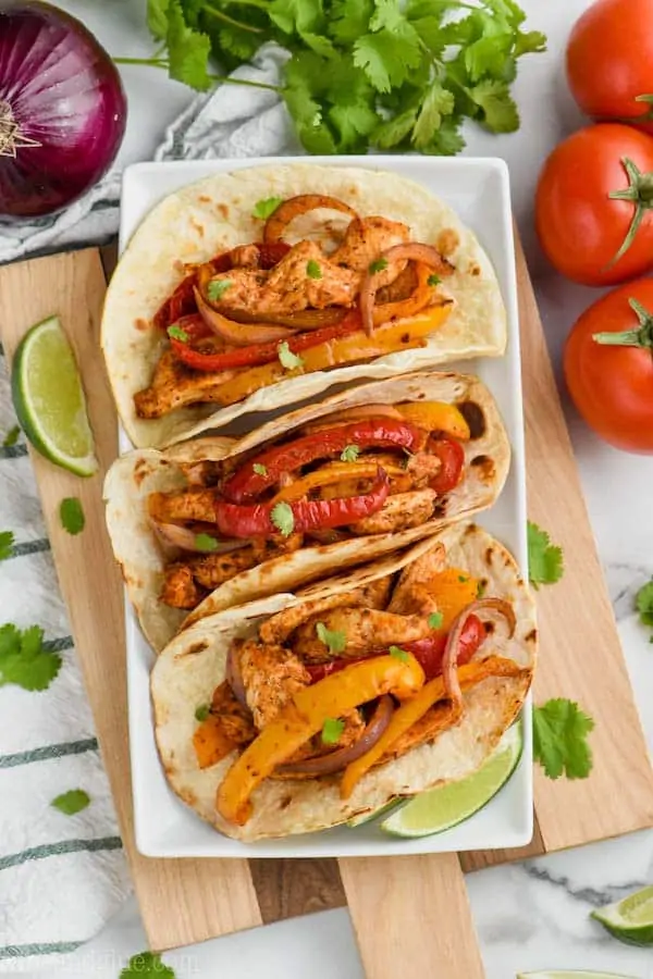 overhead view of three baked chicken fajitas in on a white plate
