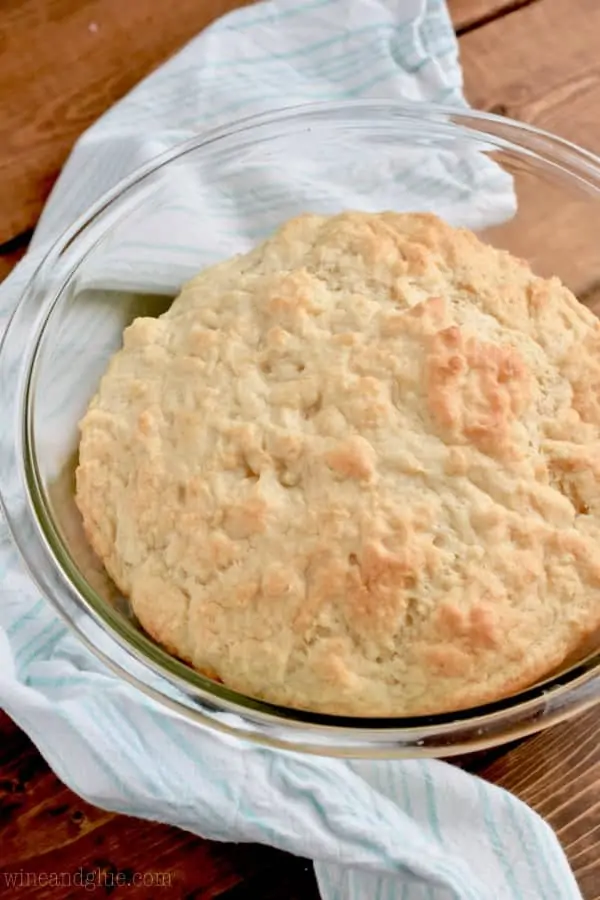 In a glass bowl, the Beer Bread Dip Bowl is baked to a golden brown crust. 