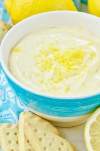 Lemon dip in bowl with shortbread and lemons sitting next to the bowl