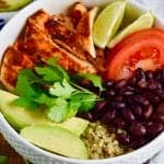Quinoa taco bowls- Chicken, lime, tomatoes, black beans, avocado quinoa in a bowl garnished with cilantro