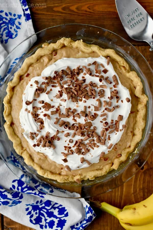Overhead photo of the Black Bottom Banana Peanut Butter Pie and topped with a small circle of whipped cream and chocolate shavings