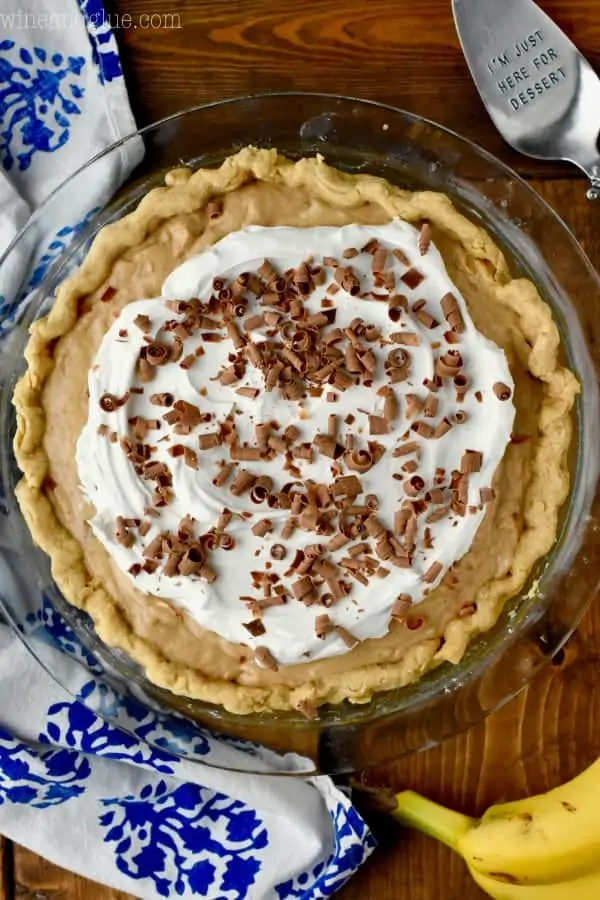 Overhead photo of the Black Bottom Banana Peanut Butter Pie and topped with a small circle of whipped cream and chocolate shavings