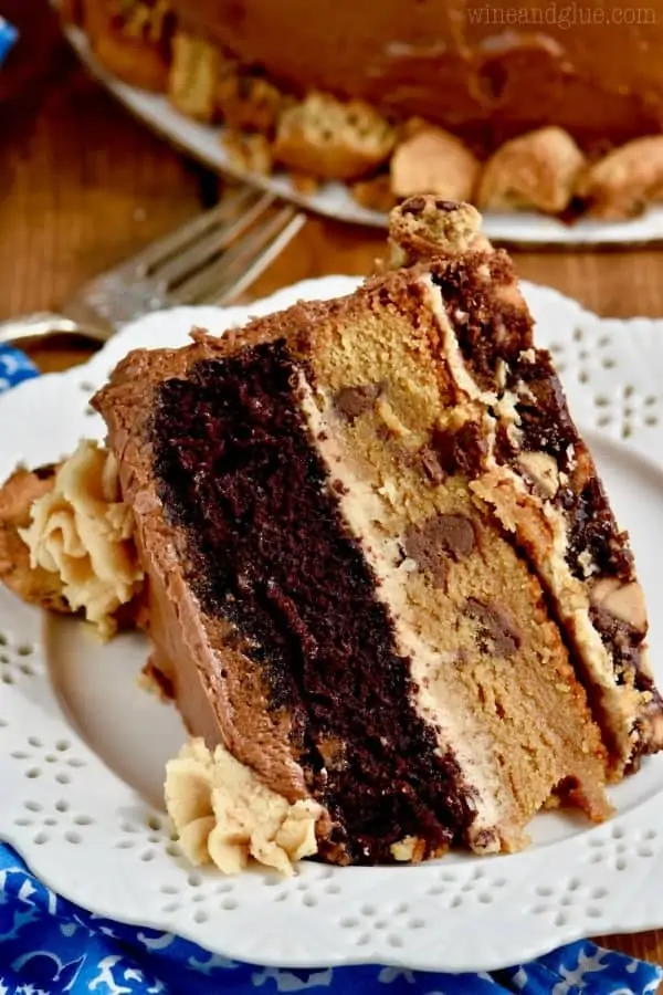 A slice of the Chocolate Peanut Butter Cookie Cake is three layers of brownie, cookie, and chocolate cake with peanut butter and chocolate frosting. 