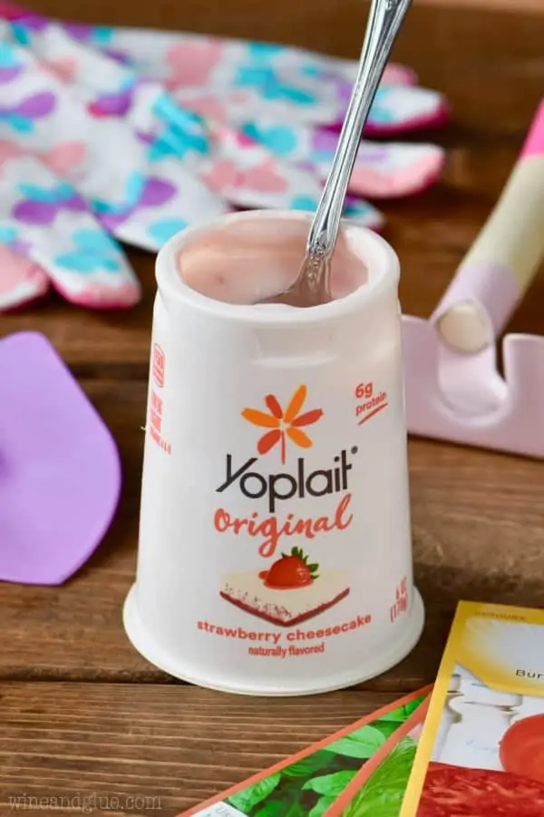 A spoon digging into the Yoplait Original Strawberry Cheesecake. 