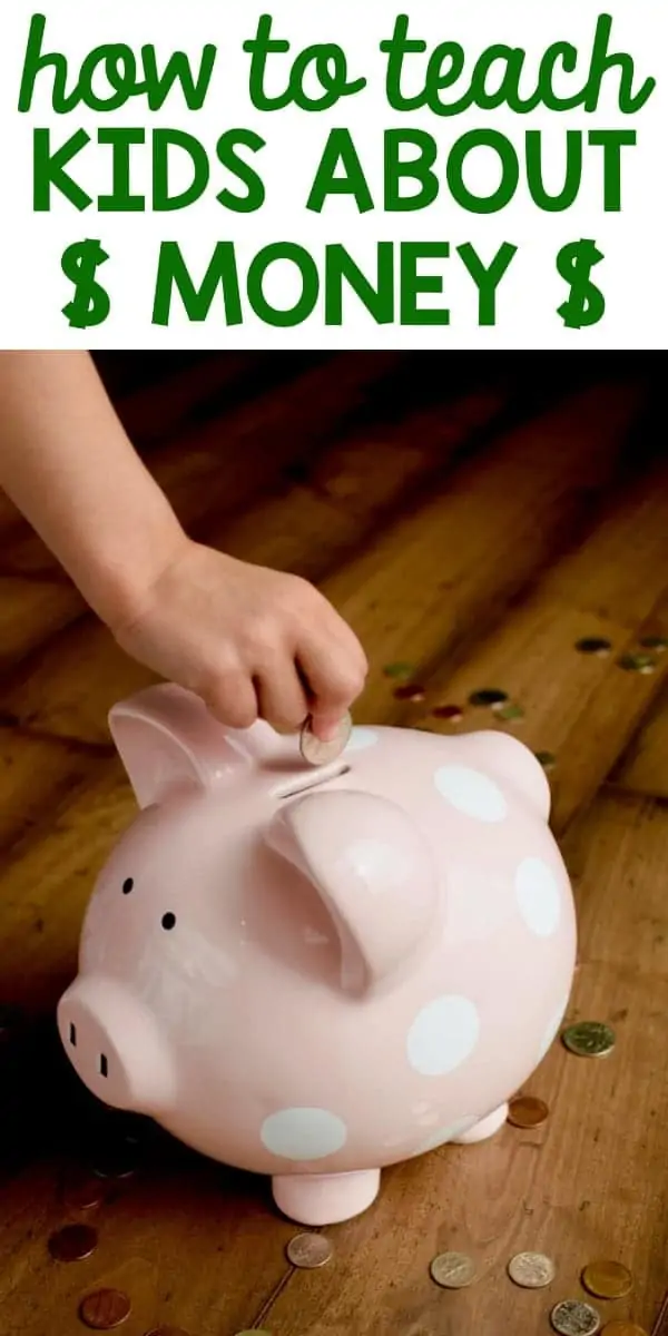 A little girl putting some coins in a pink piggy bank 