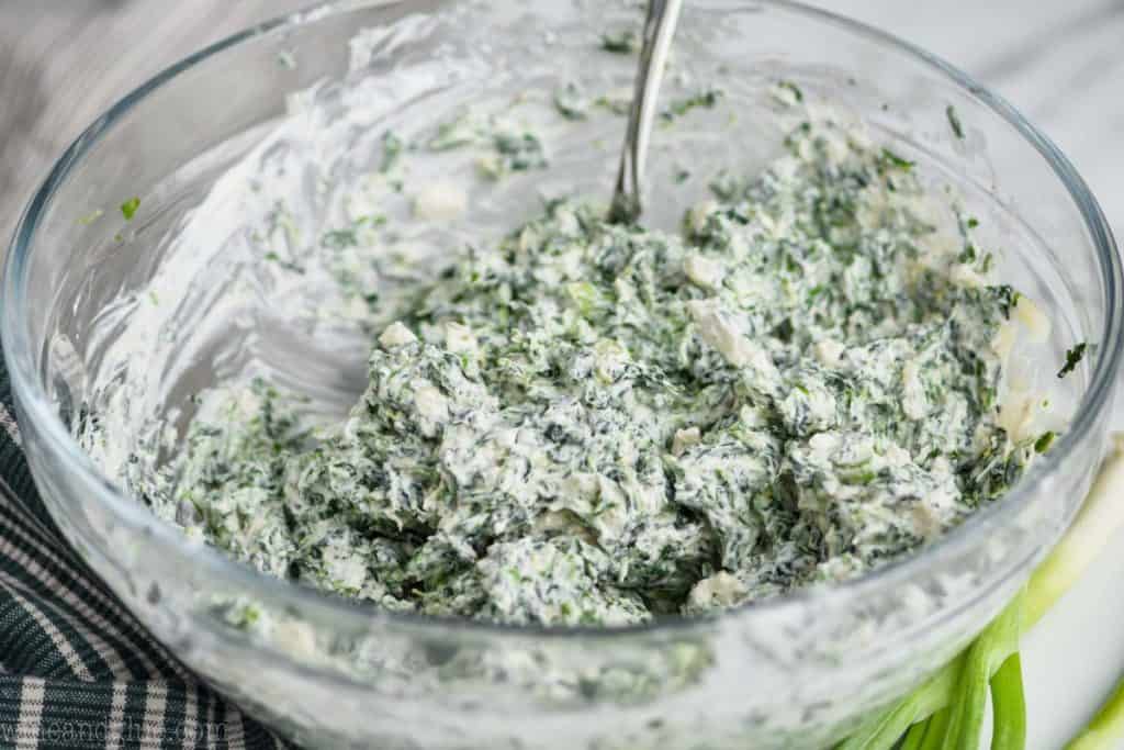 clear bowl full of easy spinach dip mixed together