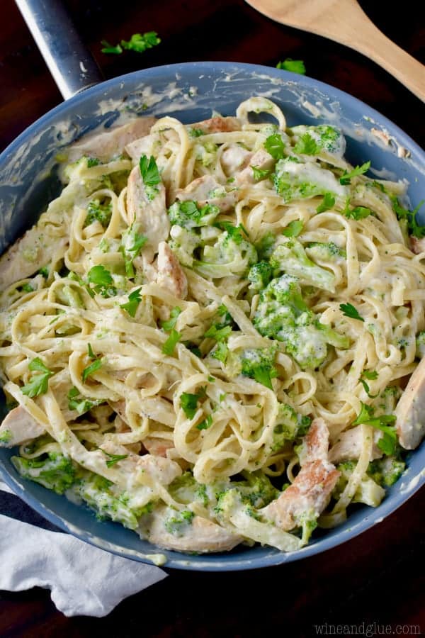 An overhead photo of the Lighter Fettuccine Alfredo showing the different color greens from the broccoli and parsley mixed in with the pasta and chicken. 