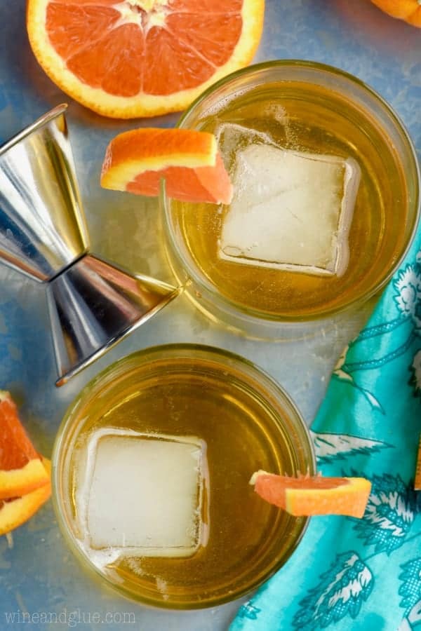 An overhead photo of two Desert Wasteland Whiskey Cocktail showing the large ice cube in the middle and a orange slice on the brim. 