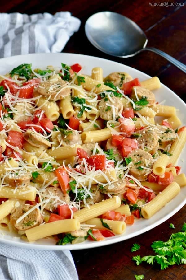 On a large dinner plate, the Sausage Pasta Skillet is topped with shredded parmesan cheese. 