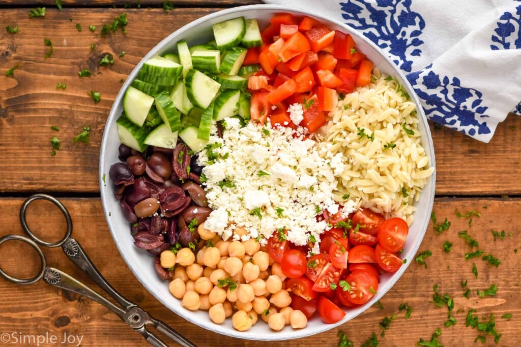 Overhead photo of a bowl of ingredients for Easy Orzo Salad recipe.