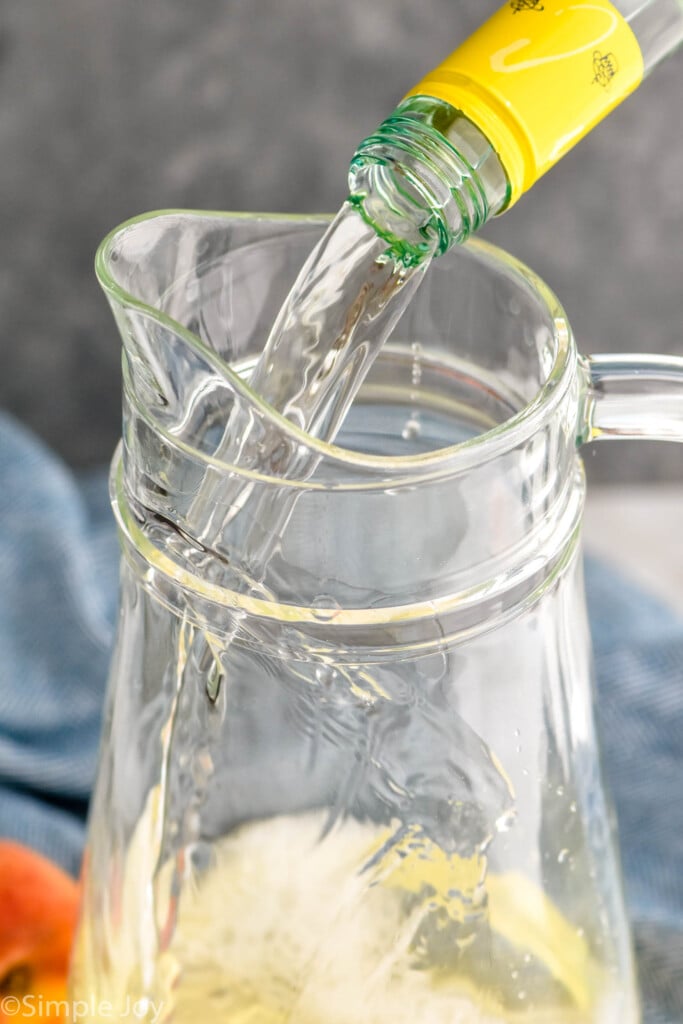 white wine being poured into a pitcher