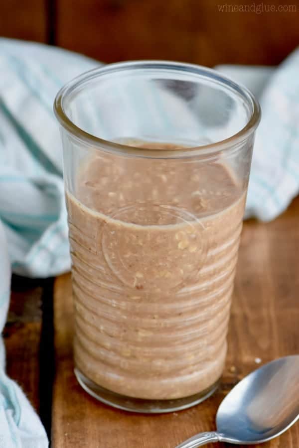 In a clear glass, the Chocolate Peanut Butter Overnight Oats as light chocolate color. 