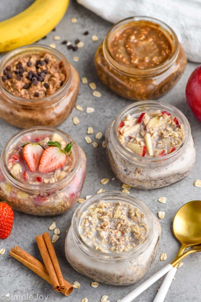 five mason jars filled with different flavors of overnight oats