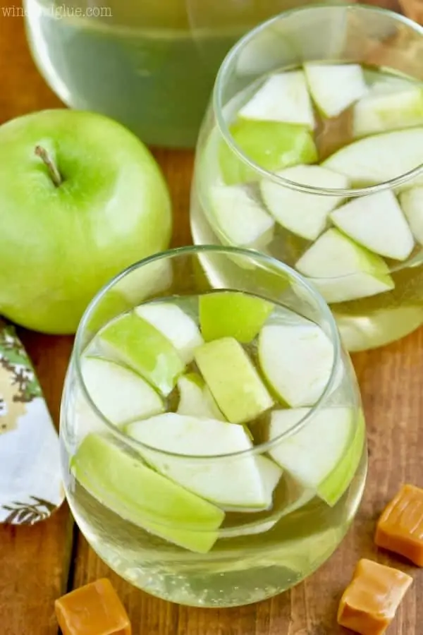 An overhead photo of two glasses filled with the Caramel Apple Sangria and sliced green apples. 