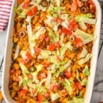overhead of baked taco casserole garnished with olives, tomatoes, and iceberg lettuce - 10
