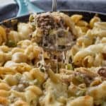skillet full of phlily cheese steak casserole with spoonful being pulled out - 9